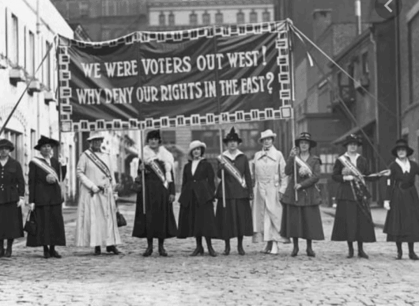 Women with Banner: We were Voters out West! Why Deny our Rights in the East?